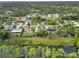 An aerial view showcases a canal community with waterfront homes amidst lush, mature greenery at 2776 Tusket Ave, North Port, FL 34286