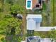 An aerial view displays the roof, driveway, adjacent pool, and shed surrounded by lush greenery at 2776 Tusket Ave, North Port, FL 34286