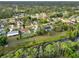 An aerial view depicts a canal community with lush greenery, mature trees, and waterfront living at 2776 Tusket Ave, North Port, FL 34286