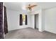 Calming bedroom featuring neutral carpet, ceiling fan, a window, and a closet at 2776 Tusket Ave, North Port, FL 34286