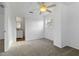 Cozy bedroom with neutral carpet, paint, ceiling fan, and view of attached bathroom at 2776 Tusket Ave, North Port, FL 34286