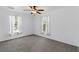 Bright bedroom featuring neutral carpeting, ceiling fan, and windows with decorative curtains at 2776 Tusket Ave, North Port, FL 34286