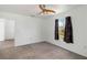 Comfortable bedroom boasts neutral carpet, a ceiling fan, and a window with dark curtains at 2776 Tusket Ave, North Port, FL 34286