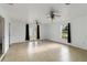 Living room with tile flooring, ceiling fans, and access to outdoor space through glass doors at 2776 Tusket Ave, North Port, FL 34286