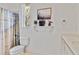 Bright bathroom featuring a toilet, shower/tub combination, and decorative shelving at 2779 N Beach Rd # A, Englewood, FL 34223
