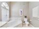 Clean bathroom with white tile, marble tub surround, and shuttered window at 2779 N Beach Rd # A, Englewood, FL 34223
