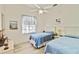 Bright bedroom with two twin beds, ceiling fan, and beach-themed decor at 2779 N Beach Rd # A, Englewood, FL 34223