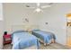 Well-lit bedroom with twin beds, ceiling fan, and light-colored walls at 2779 N Beach Rd # A, Englewood, FL 34223