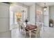 Bright dining area featuring a chandelier, white tile floors, and a view of the yard at 2779 N Beach Rd # A, Englewood, FL 34223