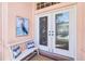 Inviting entryway with double doors, bench with blue pillows, and a heron painting at 2779 N Beach Rd # A, Englewood, FL 34223