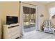 Bedroom view through glass doors, overlooking screened lanai with pool and backyard at 2779 N Beach Rd # A, Englewood, FL 34223