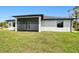Spacious backyard with a covered patio, windows, and lots of green space at 3140 Lopinto St # 1, North Port, FL 34287