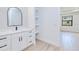 Bright bathroom features a modern vanity with black hardware, shelving, and a large, arched mirror at 3140 Lopinto St # 1, North Port, FL 34287