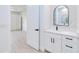 Elegant bathroom boasts a modern vanity with black hardware and a large, arched mirror with an open doorway at 3140 Lopinto St # 1, North Port, FL 34287