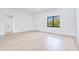 Bright bedroom with white walls, a window view, and light wood-look flooring at 3140 Lopinto St # 1, North Port, FL 34287