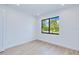 Bright bedroom featuring a black-framed window showcasing lush, tropical landscaping at 3140 Lopinto St # 1, North Port, FL 34287