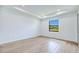 Bright bedroom with white walls, tray ceiling, a window view, and light wood-look flooring at 3140 Lopinto St # 1, North Port, FL 34287