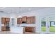 Bright kitchen with wood cabinets, an island, and modern lighting fixtures at 3140 Lopinto St # 1, North Port, FL 34287