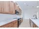 Modern kitchen featuring wood cabinets, quartz countertops, and stainless steel appliances at 3140 Lopinto St # 1, North Port, FL 34287