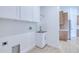 Convenient laundry room with white cabinets, sink, and tile flooring, next to kitchen at 3140 Lopinto St # 1, North Port, FL 34287