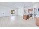 Large living room with light wood floors and a kitchen featuring a center island and stainless steel refrigerator at 3140 Lopinto St # 1, North Port, FL 34287