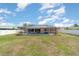 This backyard features a screened-in pool enclosure with an expansive grassy area at 3187 Elkcam Blvd, Port Charlotte, FL 33952