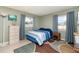 Comfortable bedroom with a blue-striped bed, dresser, and large windows at 3187 Elkcam Blvd, Port Charlotte, FL 33952