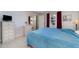 Bedroom featuring a queen bed, dresser with mirror, and tiled floors, offering a peaceful retreat at 3187 Elkcam Blvd, Port Charlotte, FL 33952