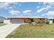 Charming single Gathering home with an attached garage, arched entry and nicely maintained landscaping in the front yard at 3187 Elkcam Blvd, Port Charlotte, FL 33952