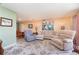 Cozy living room featuring comfortable seating, neutral decor, and a patterned rug, perfect for relaxing and entertaining at 3187 Elkcam Blvd, Port Charlotte, FL 33952