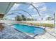 Sparkling pool with brick-paver deck and screen enclosure, surrounded by a meticulously landscaped backyard at 3187 Elkcam Blvd, Port Charlotte, FL 33952