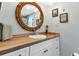 Bright bathroom with wooden vanity, framed mirror, and updated sink and fixtures at 3215 Cedarbrook Dr, Punta Gorda, FL 33982