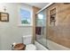 Bright bathroom with walk-in shower, tiled walls, toilet, and window at 3215 Cedarbrook Dr, Punta Gorda, FL 33982