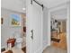 Bathroom with a sliding white barn door, toilet, walk-in shower and window view at 3215 Cedarbrook Dr, Punta Gorda, FL 33982