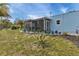 Rear view of the house with screened patio surrounded by well-manicured lawn and tasteful landscaping at 3215 Cedarbrook Dr, Punta Gorda, FL 33982