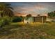Exterior shot of house from the yard featuring a screened porch, lush landscaping, and exterior paint at 3215 Cedarbrook Dr, Punta Gorda, FL 33982