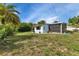 Exterior shot of house from the yard featuring a screened porch, lush landscaping, and exterior paint at 3215 Cedarbrook Dr, Punta Gorda, FL 33982