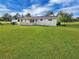 Expansive backyard with lush lawn, mature trees, and a screened-in porch at 3420 Dawson Ln, Punta Gorda, FL 33982