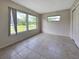 Light-filled bedroom featuring tile floors and windows overlooking the landscaped yard at 3420 Dawson Ln, Punta Gorda, FL 33982