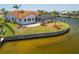Waterfront home with a red tile roof, a screened lanai, and lush landscaping at 3705 Toulouse Ct, Punta Gorda, FL 33950