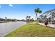 Lovely backyard featuring a canal view, lush lawn, and screened lanai with tropical palm trees at 3705 Toulouse Ct, Punta Gorda, FL 33950