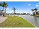 Lush backyard featuring a canal view and tropical palm trees near the paver patio at 3705 Toulouse Ct, Punta Gorda, FL 33950