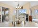 Dining area with glass table, chairs, chandelier, and view of the screened-in patio and waterfront at 3705 Toulouse Ct, Punta Gorda, FL 33950
