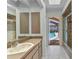 Well-lit bathroom with a large mirror, vanity, tiled shower, and a door leading to the pool at 3824 Aves Island Ct, Punta Gorda, FL 33950