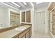 Bright bathroom with a large mirror, vanity, tiled shower, and a door leading outside at 3824 Aves Island Ct, Punta Gorda, FL 33950