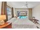 Sunlit bedroom featuring a queen-sized bed, tile flooring, a ceiling fan, and a sliding door to the screened lanai at 3824 Aves Island Ct, Punta Gorda, FL 33950