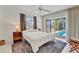 Bright bedroom with a queen-sized bed, tile flooring, pool views, and a ceiling fan at 3824 Aves Island Ct, Punta Gorda, FL 33950