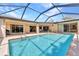 Wide view of the blue in-ground screened pool and backyard patio at 3824 Aves Island Ct, Punta Gorda, FL 33950