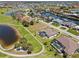 An aerial view shows this house nestled on a manicured lawn next to a golf course and a pond at 4001 La Costa Island Ct, Punta Gorda, FL 33950