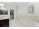 Large main bathroom with double sinks, a soaking tub, and a walk-in closet at 4001 La Costa Island Ct, Punta Gorda, FL 33950